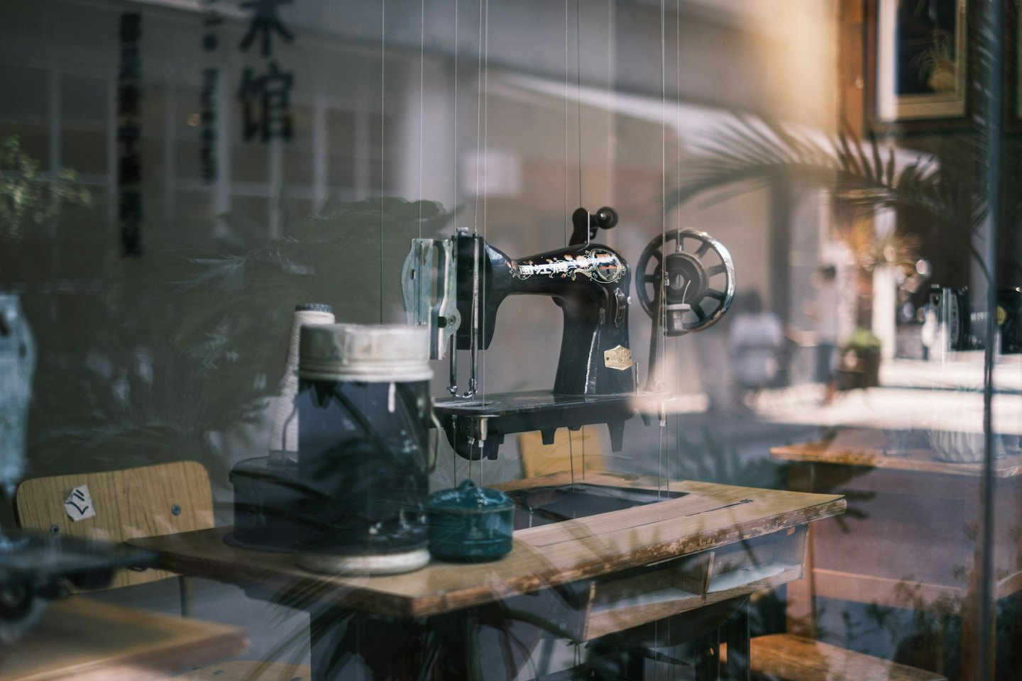 Vintage sewing machine displayed on a wooden shop window table.